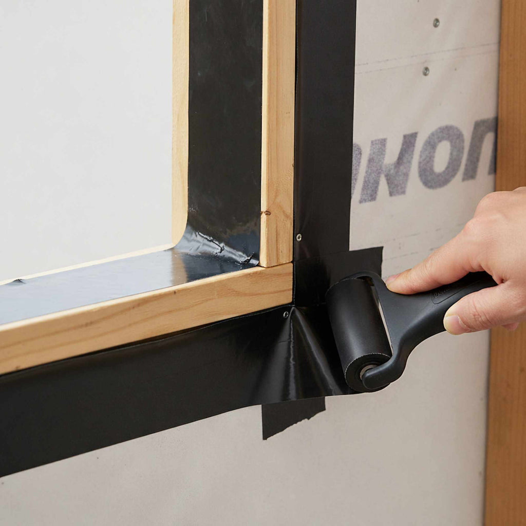 Close-up of butyl flashing tape applied to window frame corner for exterior waterproofing